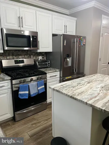 a kitchen with stainless steel appliances a stove a microwave and a refrigerator