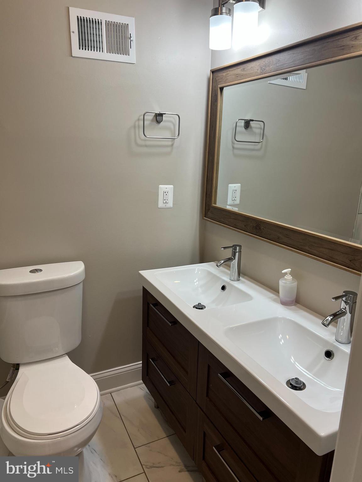 3319 Noble Street Baltimore, MD 21224 - Photo 23 of 31 a bathroom with a toilet sink and mirror