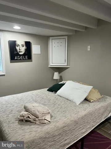 a bedroom with a bed and painting on the wall