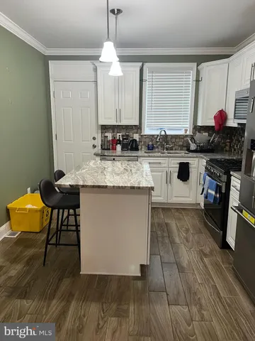 a kitchen with a sink cabinets and wooden floor