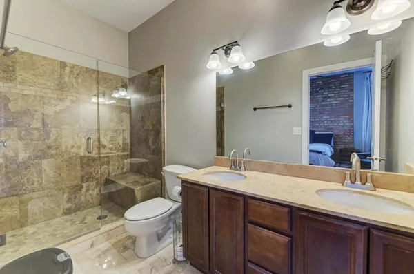 a bathroom with a double vanity sink toilet and shower