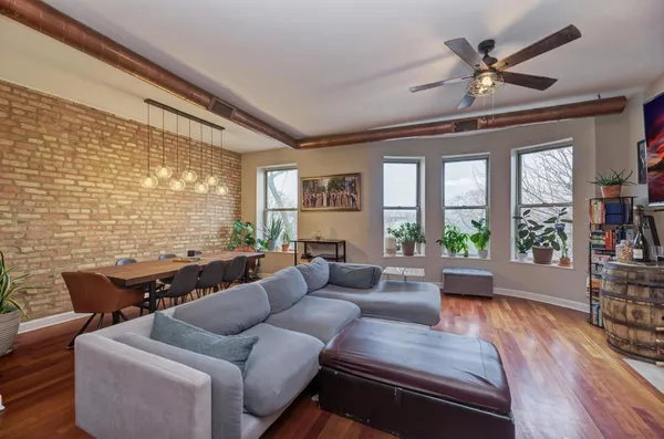 a living room with furniture and a large window with wooden floor