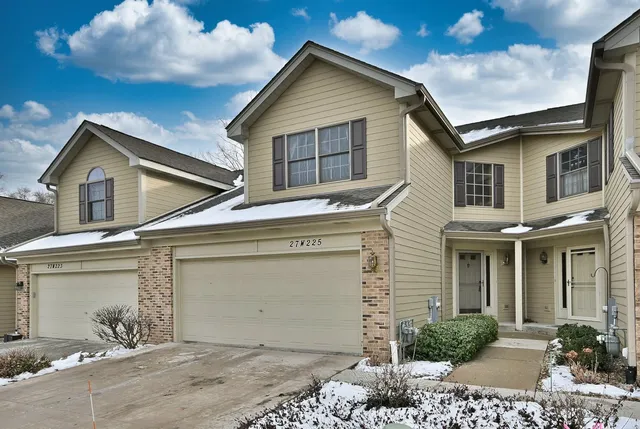a view of a house with a small yard and wooden fence
