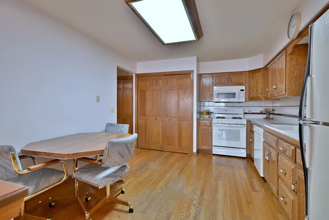 a kitchen with table chairs refrigerator and cabinets