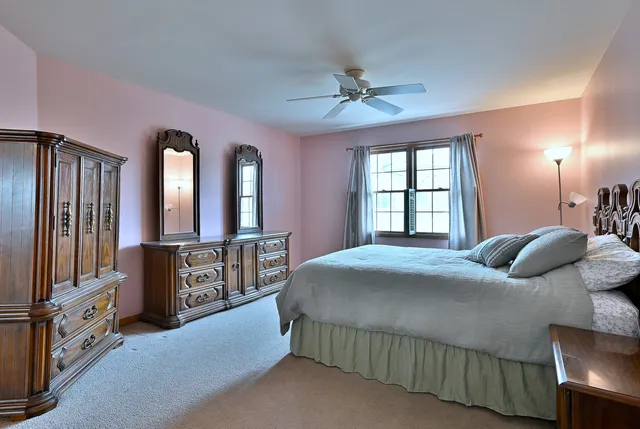 a spacious bedroom with a bed and a dresser next to a window