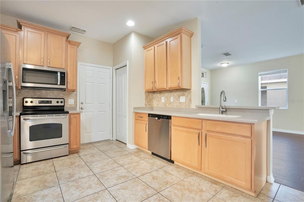 15031 Skip Jack Loop Lakewood Ranch, FL 34202 - Photo 10 of 27 a kitchen with granite countertop a stove top oven microwave and cabinets