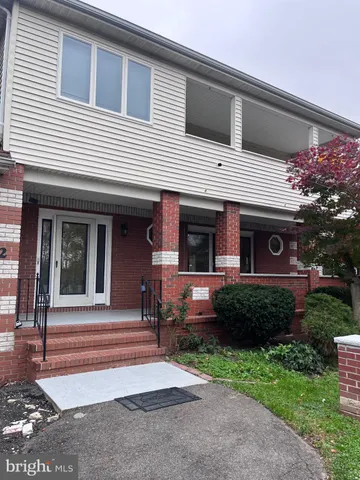 a view of a house with brick walls and a yard with plants