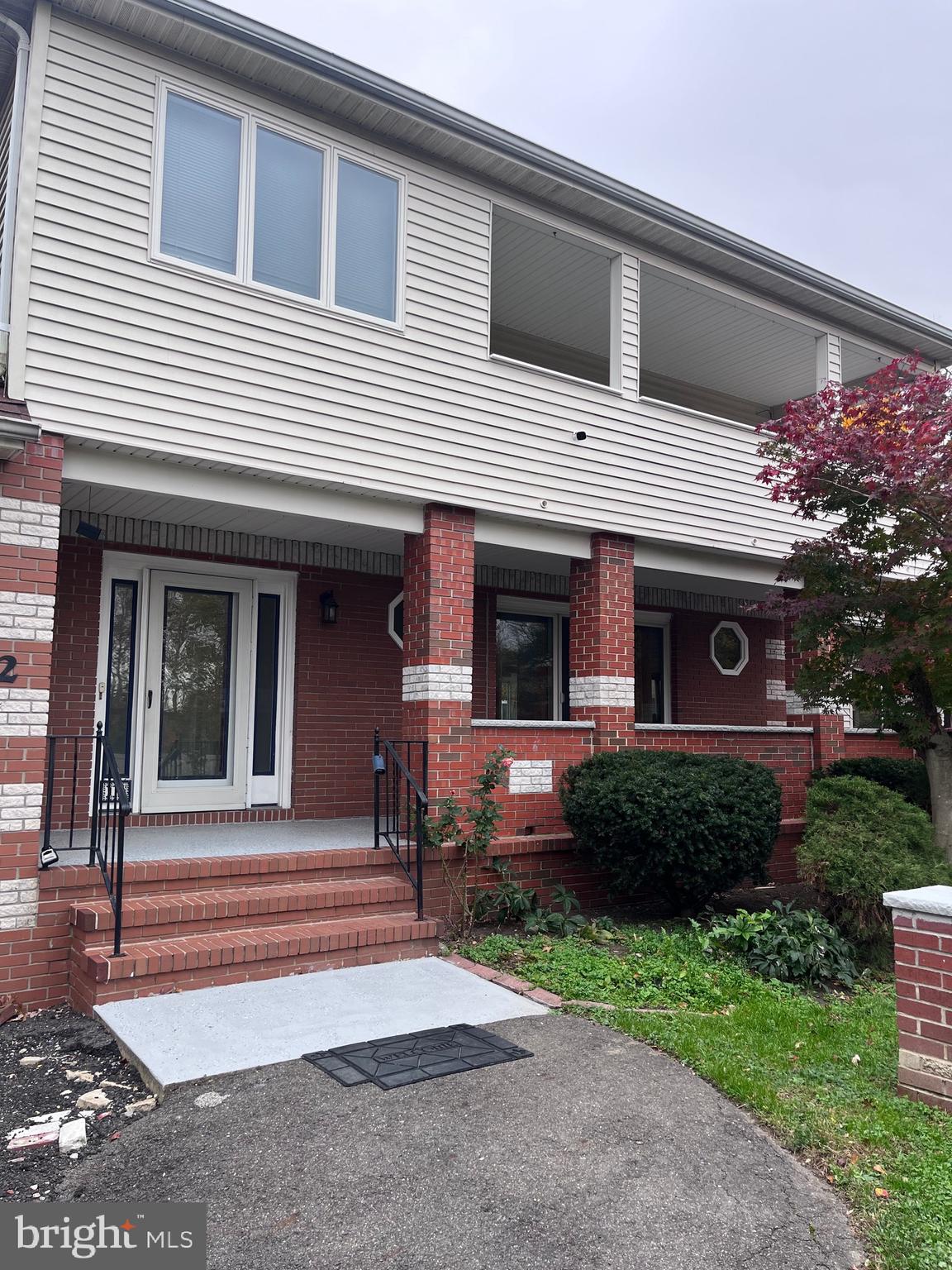 a view of a house with brick walls and a yard with plants
