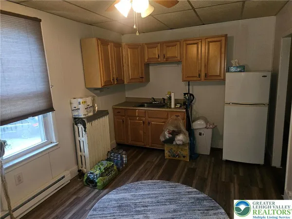 a kitchen with a refrigerator a stove a sink dishwasher and wooden floor