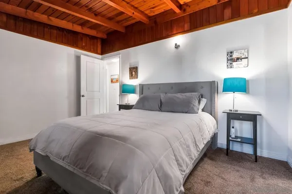 a spacious bedroom with a bed and a lamp