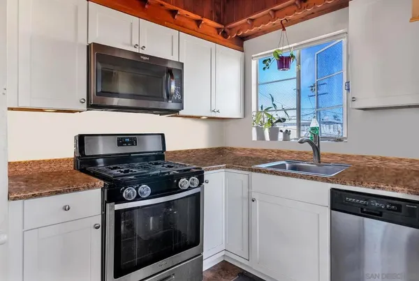 a kitchen with stainless steel appliances granite countertop a sink stove top oven and microwave