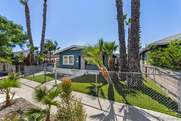 a view of a backyard with couches plants and palm tree