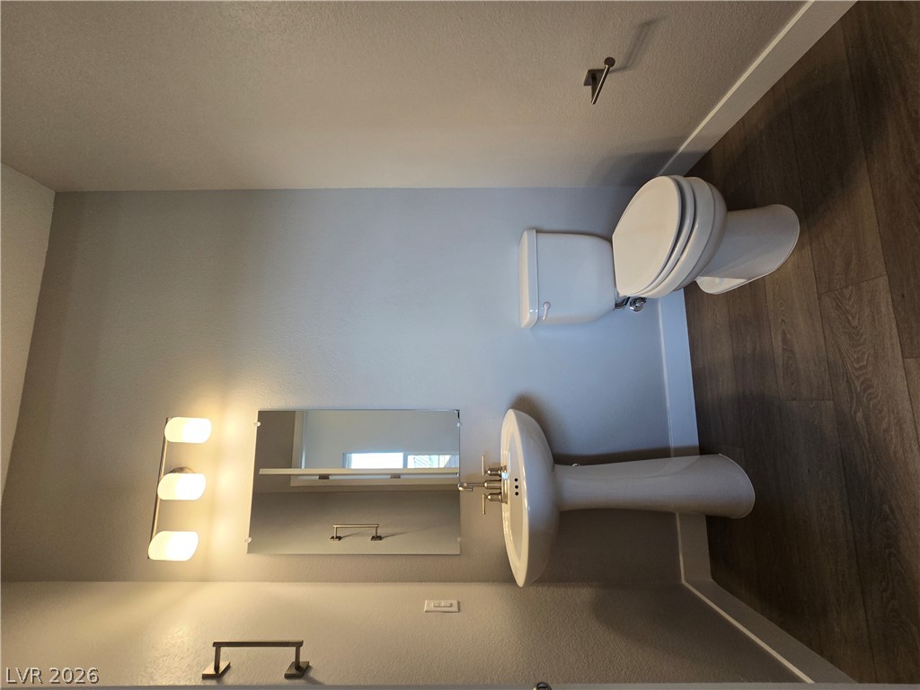 852 Weston Ridge Street Henderson, NV 89011 - Photo 22 of 28 A streamlined pedestal sink and toilet complement the wood-look flooring in this tidy bathroom.