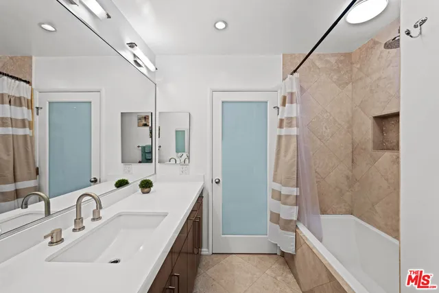a bathroom with a tub sink and mirror