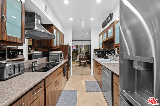 a kitchen with stainless steel appliances granite countertop a refrigerator a stove top oven a sink and dishwasher