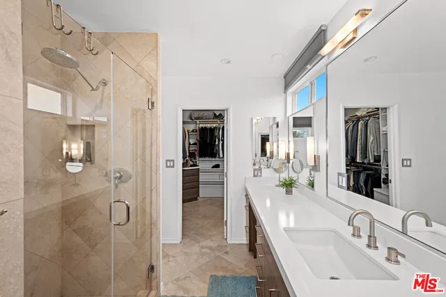 a bathroom with a double vanity sink a mirror and shower
