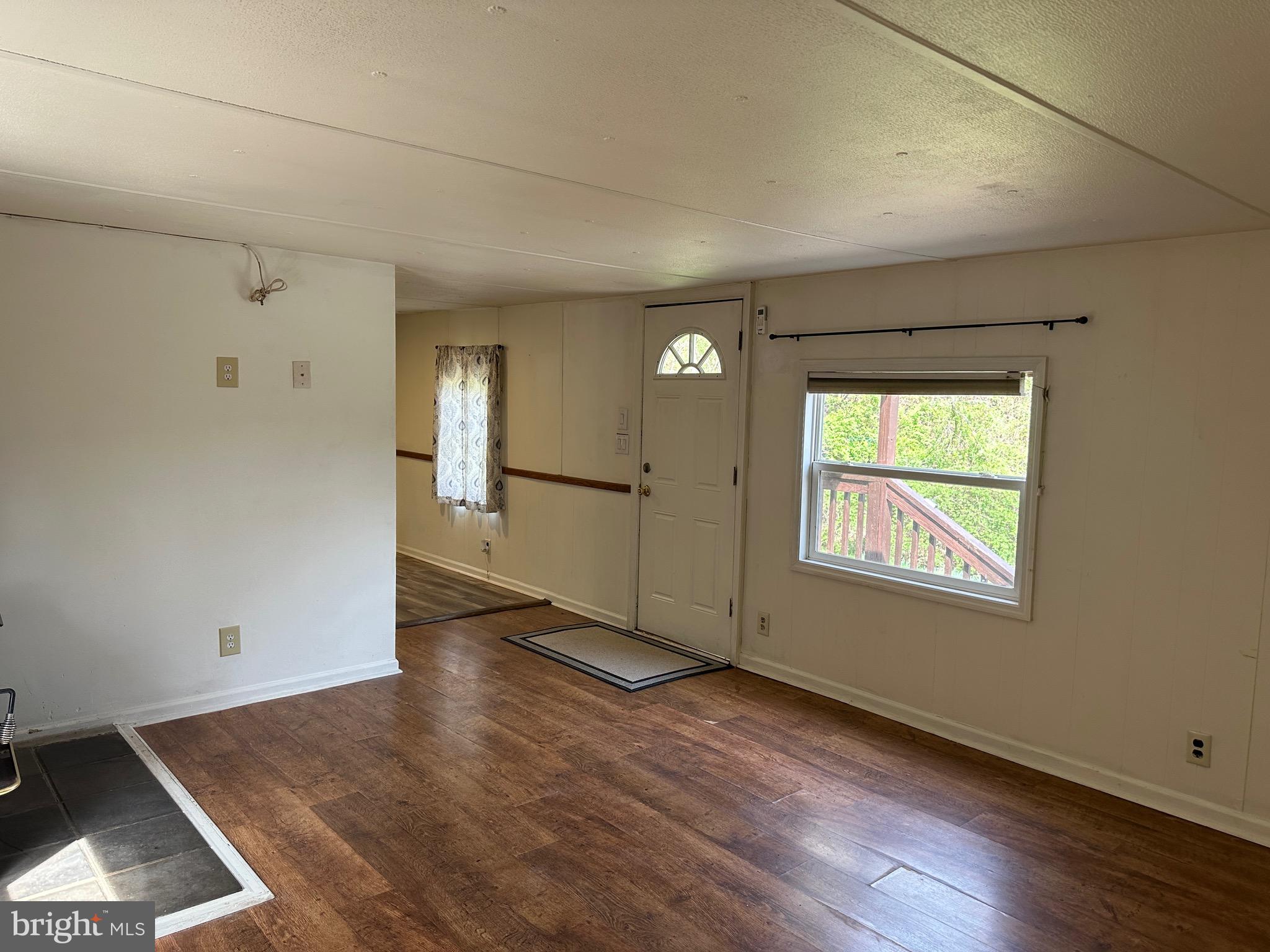 2084 Silvers Road Berkeley Springs, WV 25411 - Photo 4 of 31 an empty room with wooden floor and windows
