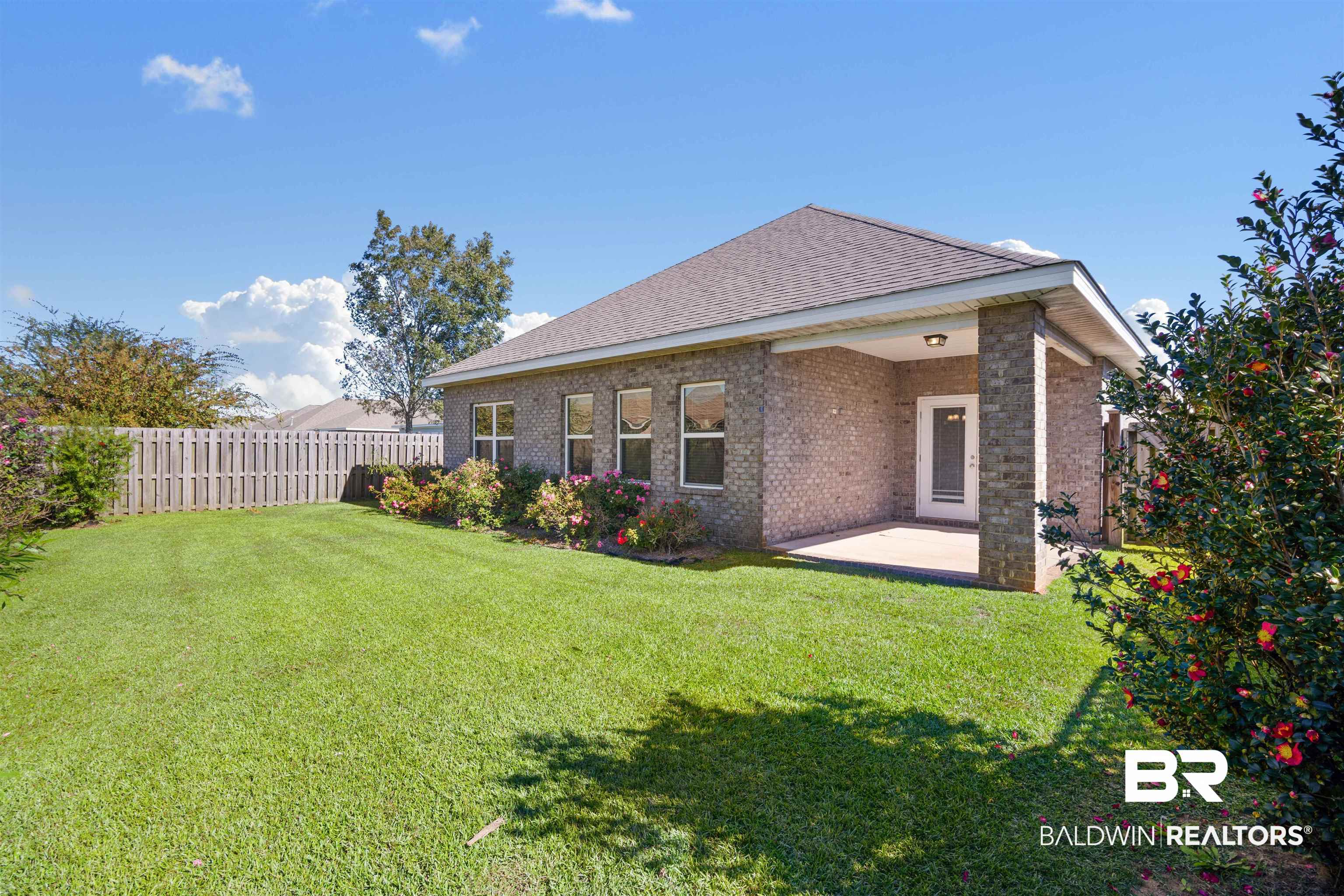 24479 Kipling Court Daphne, AL 36526 - Photo 25 of 41 Back of property with a patio area, brick siding, a fenced backyard, and a shingled roof
