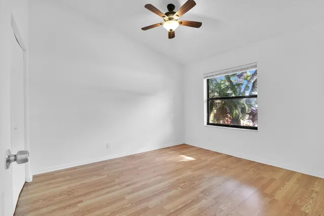 an empty room with a window and a fan