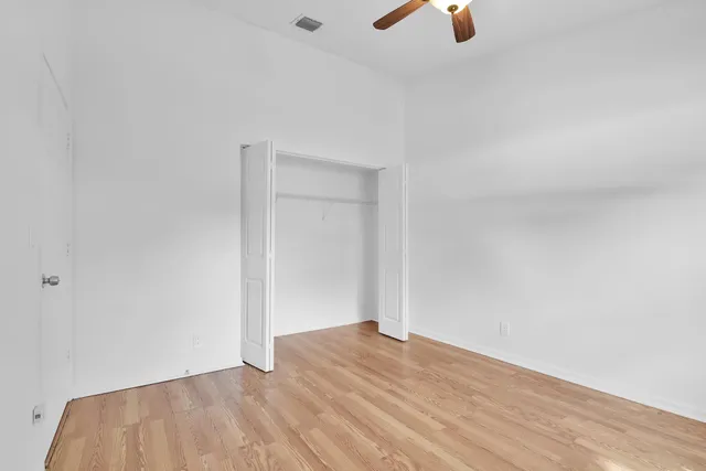 an empty room with ceiling fan and window