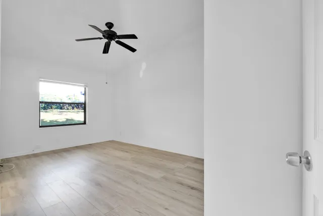 a view of room with hardwood floor and ceiling fan