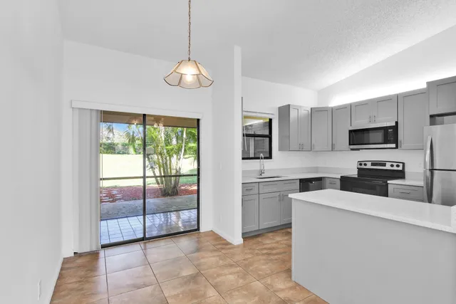 a view of a kitchen with stainless steel appliances granite countertop a stove top oven