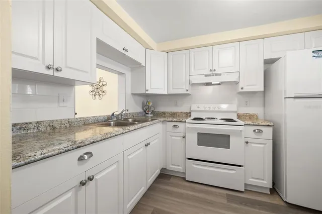 a kitchen with white cabinets and white appliances