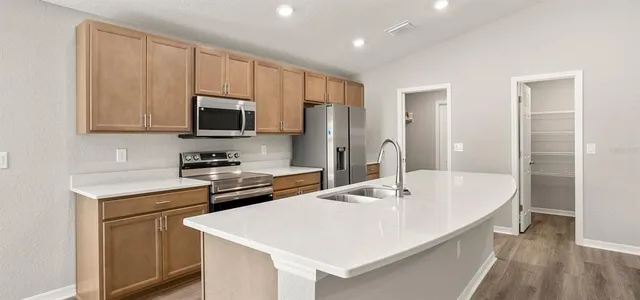 a kitchen with granite countertop a refrigerator and a sink