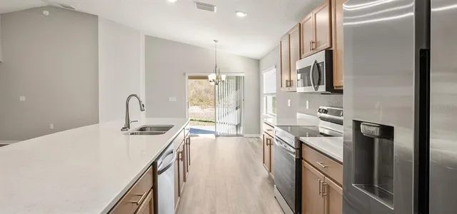 a kitchen with stainless steel appliances granite countertop a sink stove and refrigerator