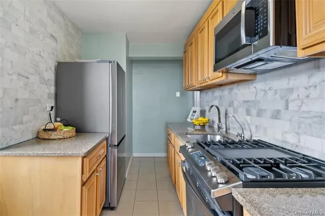 a kitchen with stainless steel appliances granite countertop a stove and a refrigerator