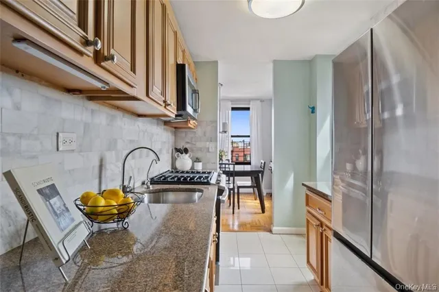 a kitchen with stainless steel appliances granite countertop a sink and a refrigerator