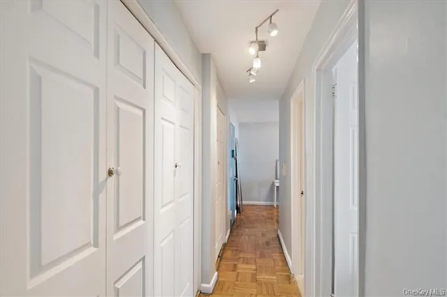 a view of a hallway with a door and chandelier