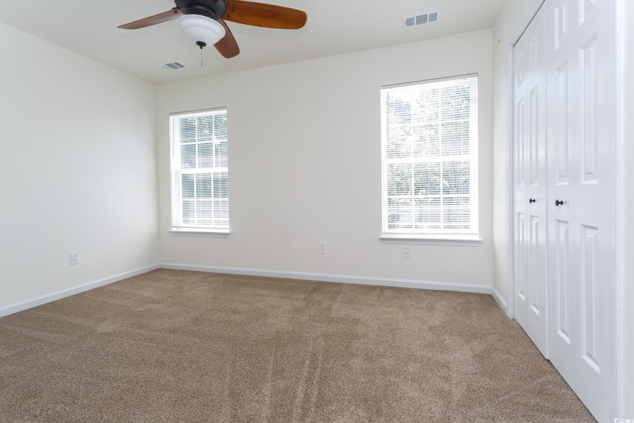 116 Barnacle Lane, Unit 1 Little River, SC 29566 - Photo 11 of 27 Unfurnished bedroom featuring carpet flooring, a closet, and a ceiling fan