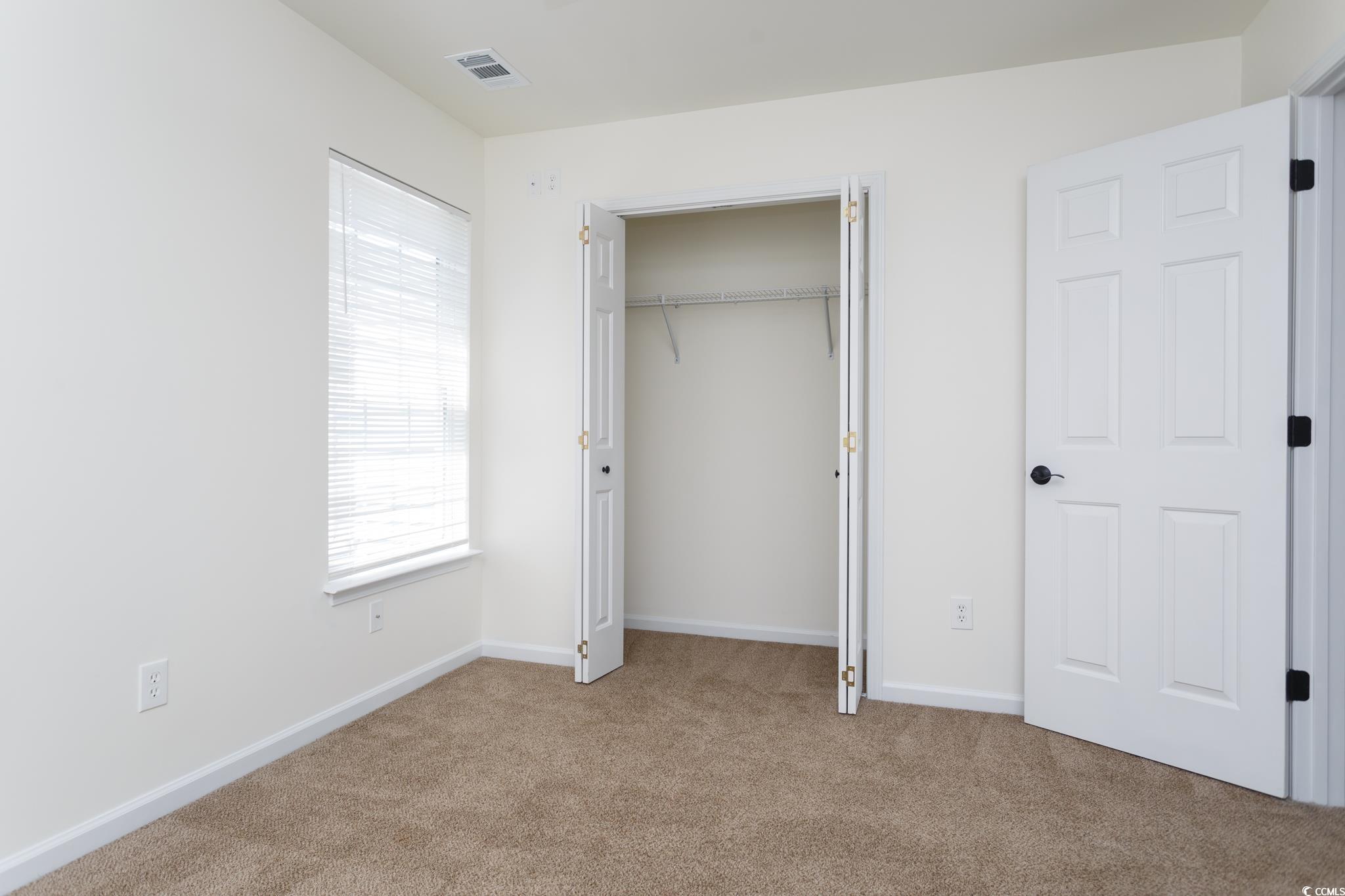 116 Barnacle Lane, Unit 1 Little River, SC 29566 - Photo 12 of 27 Unfurnished bedroom featuring light carpet and a closet