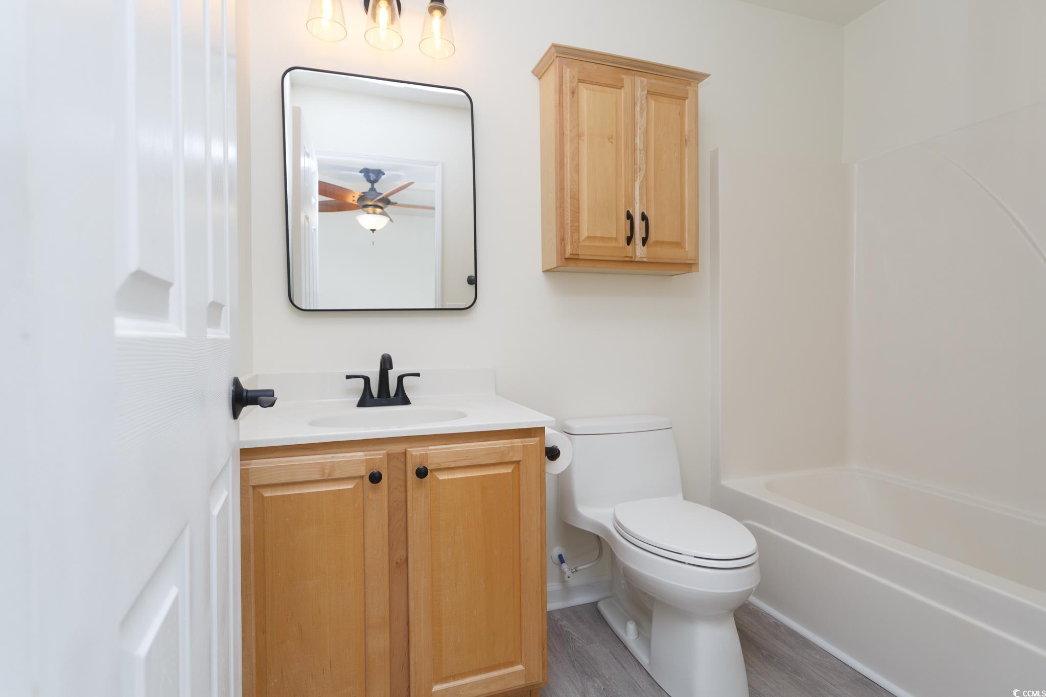 116 Barnacle Lane, Unit 1 Little River, SC 29566 - Photo 14 of 27 Bathroom featuring vanity, wood finished floors, and washtub / shower combination