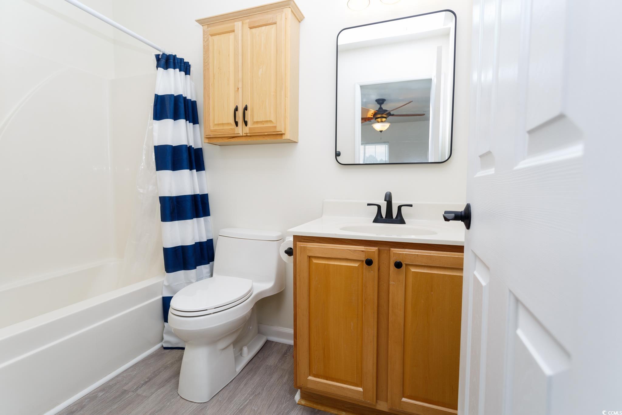 116 Barnacle Lane, Unit 1 Little River, SC 29566 - Photo 18 of 27 Bathroom with vanity, shower / bath combination with curtain, and light wood-style flooring