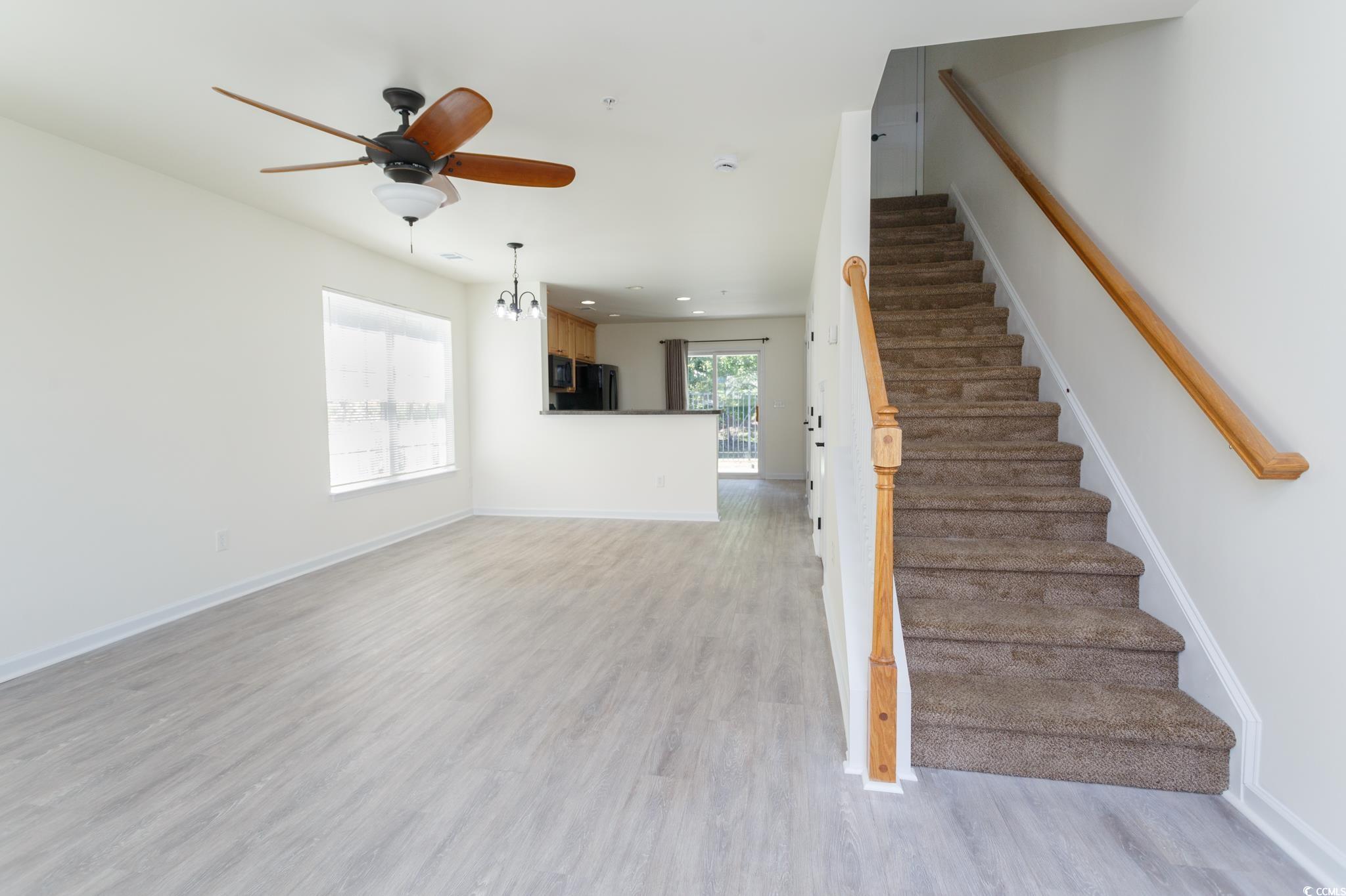 116 Barnacle Lane, Unit 1 Little River, SC 29566 - Photo 4 of 27 Stairway featuring wood finished floors, ceiling fan, a chandelier, and recessed lighting