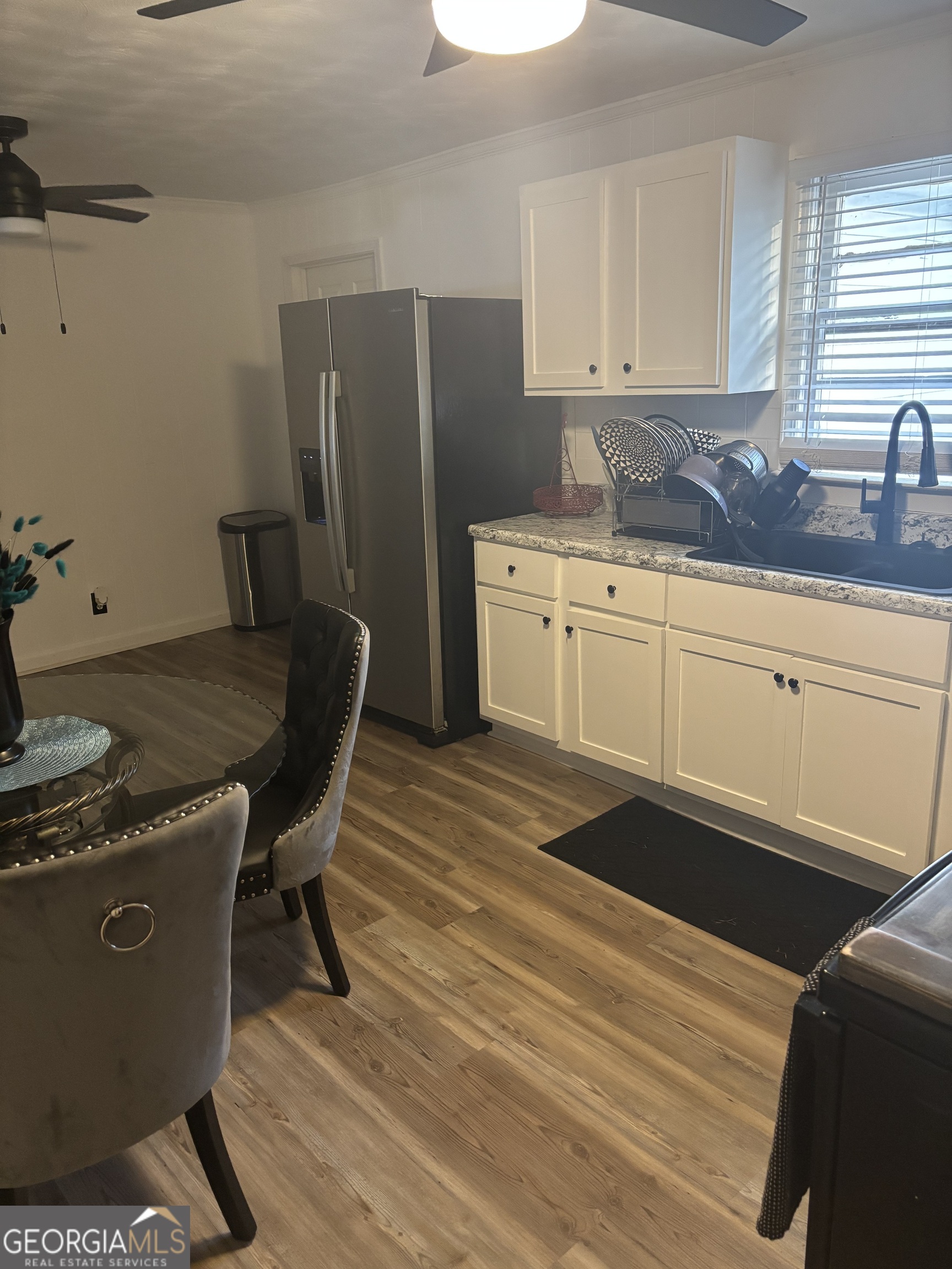 614 Alfred C Carson Street Sandersville, GA 31082 - Photo 14 of 22 a kitchen with stainless steel appliances granite countertop a refrigerator a sink dishwasher a stove a dining table and chairs with wooden floor