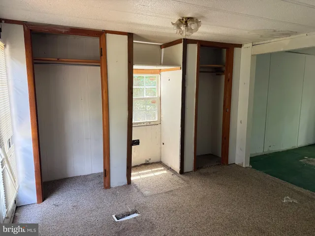 an empty room with closet and a chandelier fan
