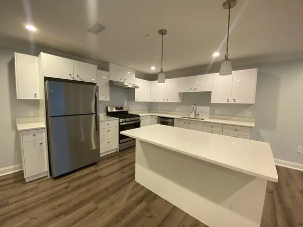 a kitchen with stainless steel appliances granite countertop a refrigerator a sink dishwasher a stove and a refrigerator