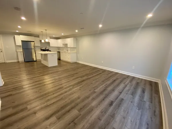 a view of empty room with wooden floor