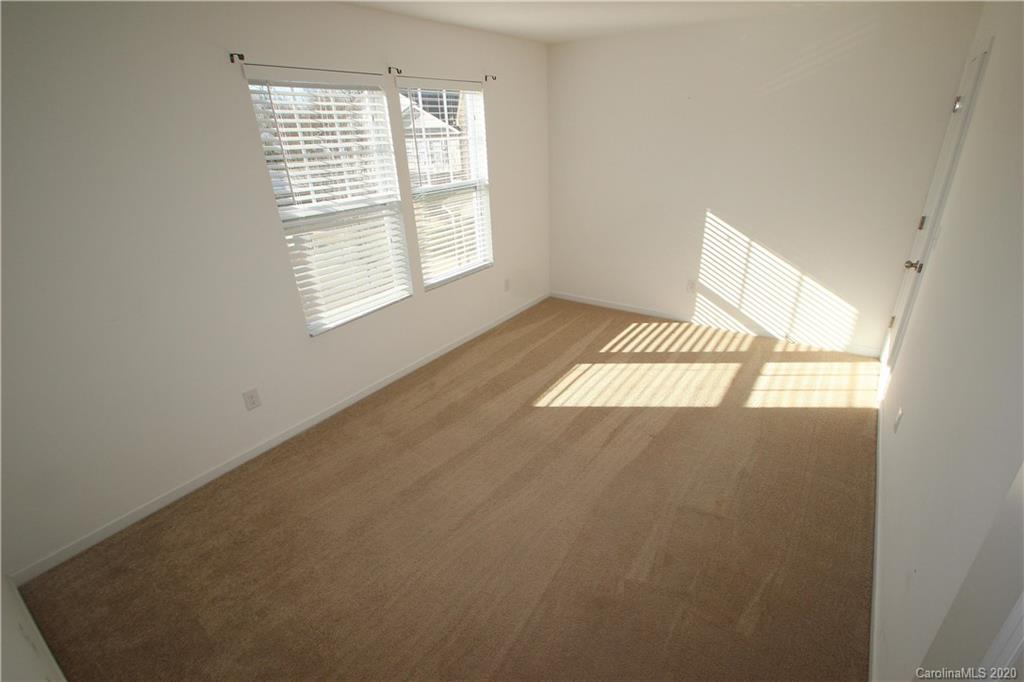 10603 Pointer Ridge Drive Charlotte, NC 28214 - Photo 24 of 37 an empty room with wooden floor and windows