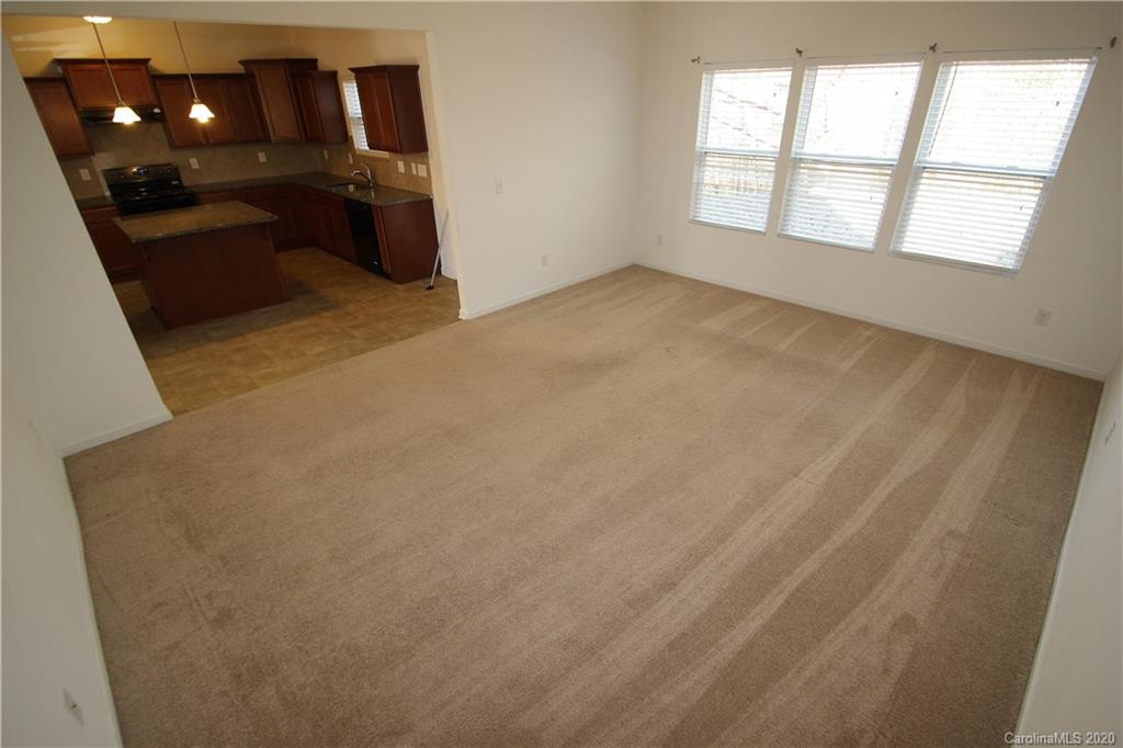 10603 Pointer Ridge Drive Charlotte, NC 28214 - Photo 7 of 37 an empty room with chandelier fan and windows