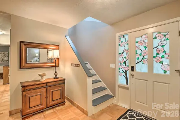 a living room with furniture a rug and a dining table