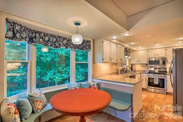 a kitchen with stainless steel appliances granite countertop a stove a sink and a refrigerator