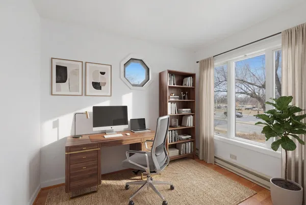 a view of a workspace with furniture and a window