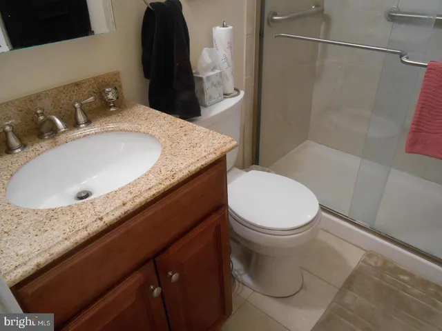 a bathroom with a granite countertop sink toilet and shower
