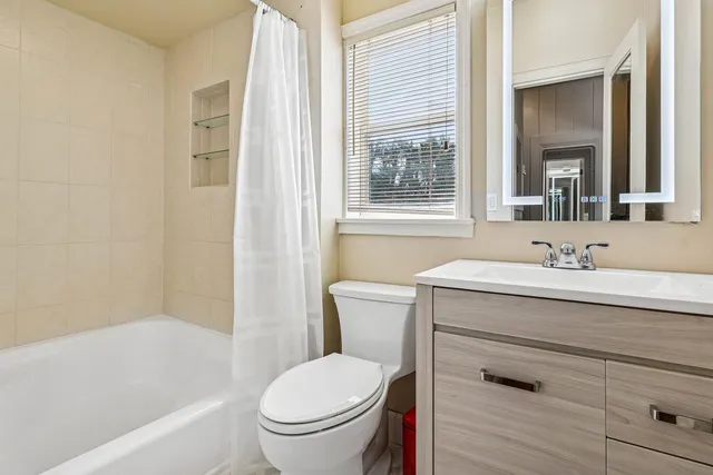 a bathroom with a granite countertop toilet a sink and a bathtub