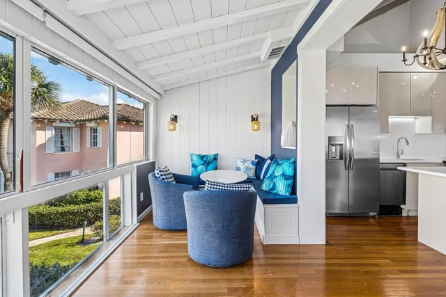 a view of kitchen with stainless steel appliances wooden floor and dining table chairs
