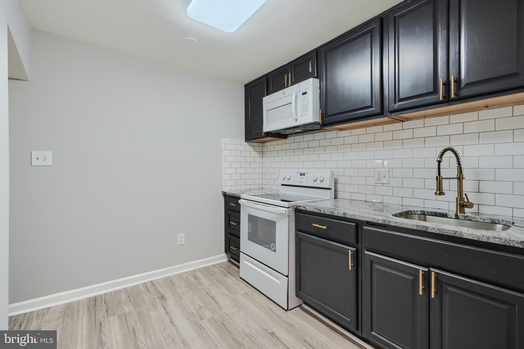 3014 Hamilton Avenue, Unit 1 Baltimore, MD 21214 - Photo 12 of 36 a kitchen with sink a microwave and cabinets
